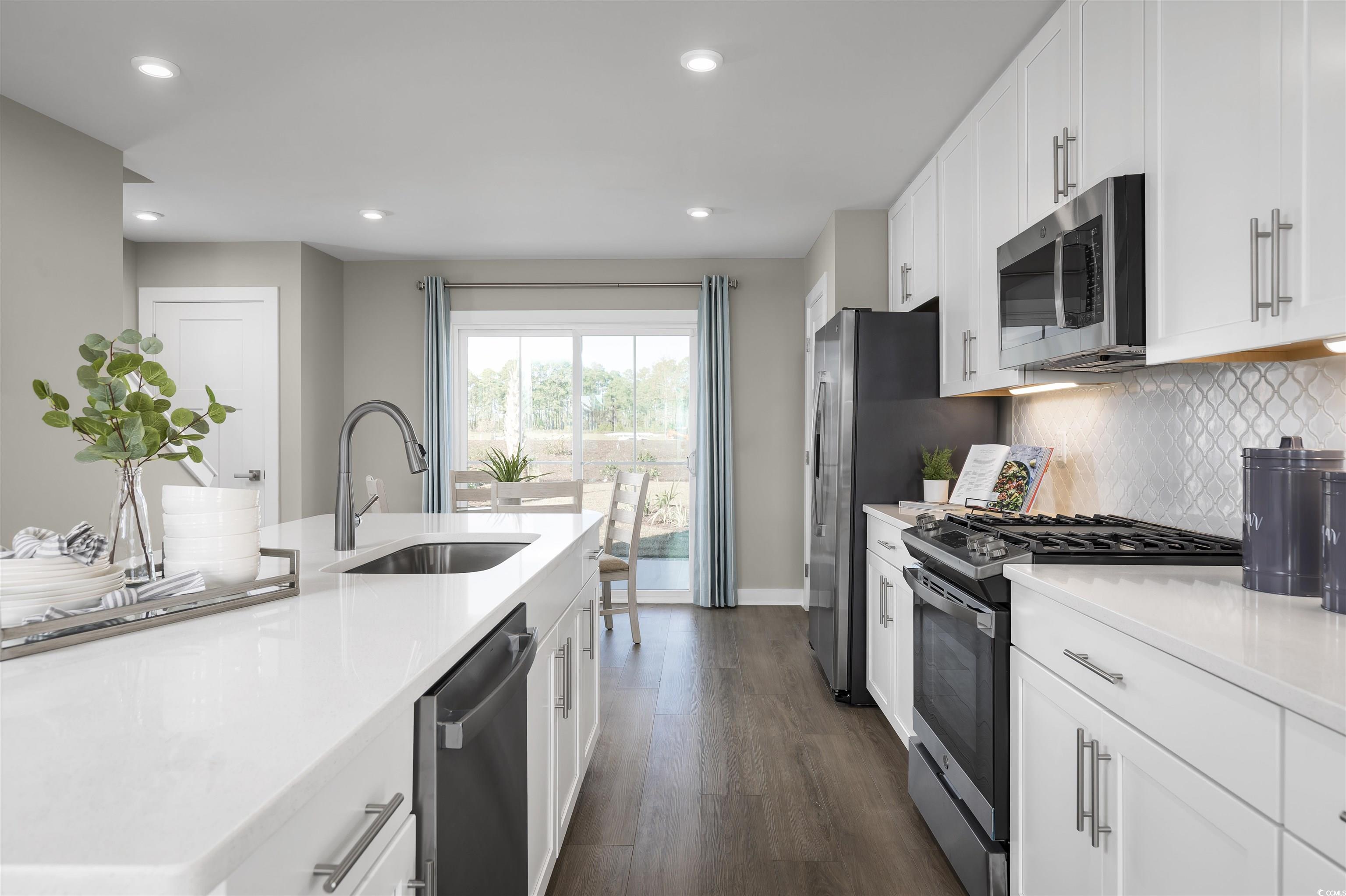 2760 Rowyn Street Longs, SC 29568 - Photo 2 of 16 Kitchen featuring stainless steel appliances, white cabinetry, sink, backsplash, and dark wood-type flooring