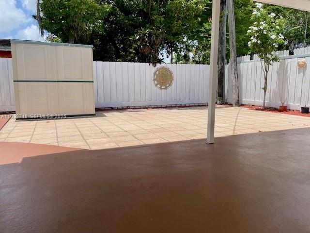 330 West 40th Place Hialeah, FL 33012 - Photo 16 of 20 a view of a white house with a outdoor space and wooden fence