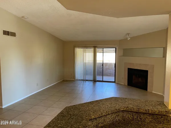 a view of an empty room with a fireplace and a window