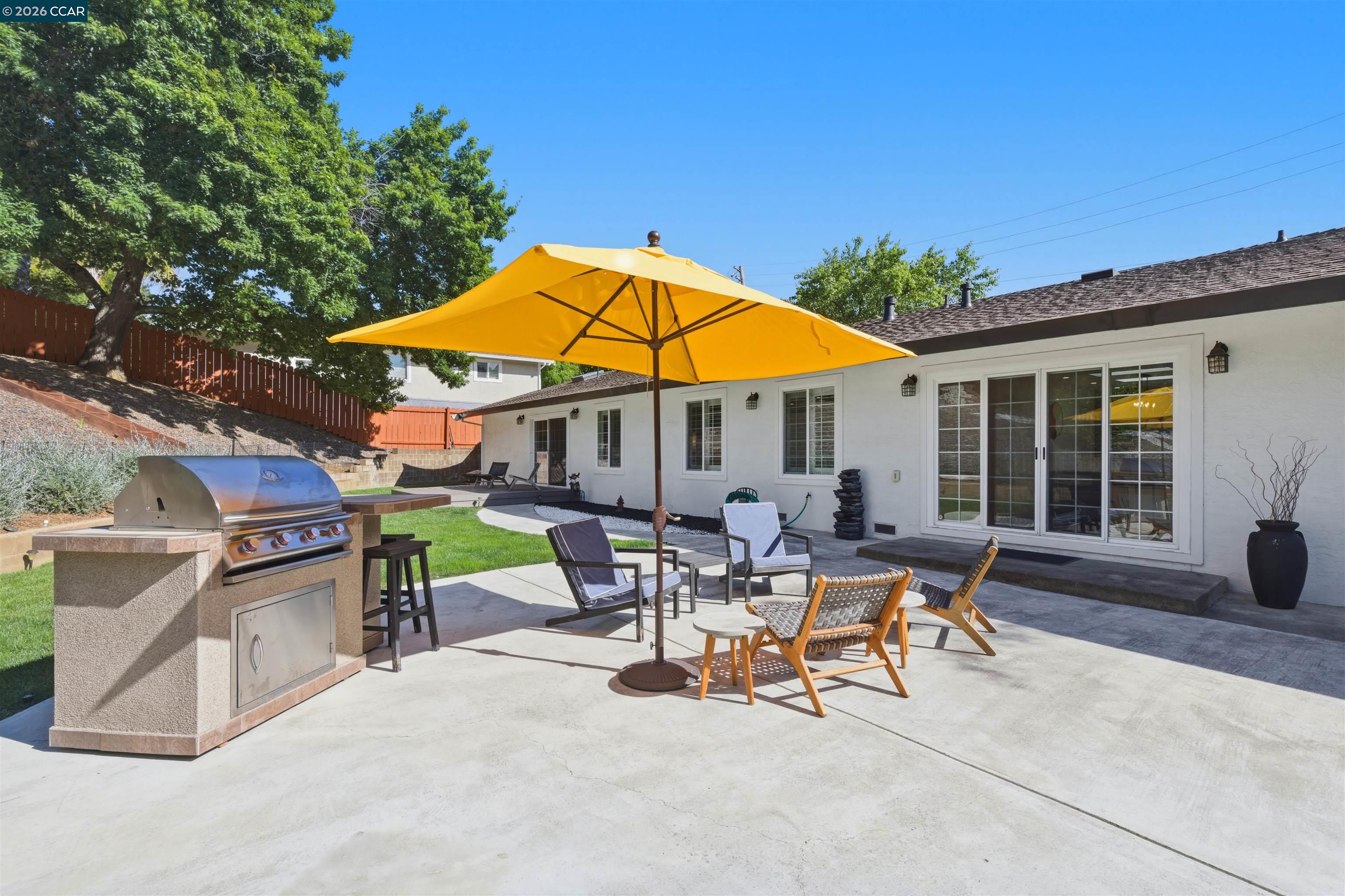 3298 Gloria Terrace Lafayette, CA 94549 - Photo 11 of 40 a view of a patio with a table and chairs under an umbrella