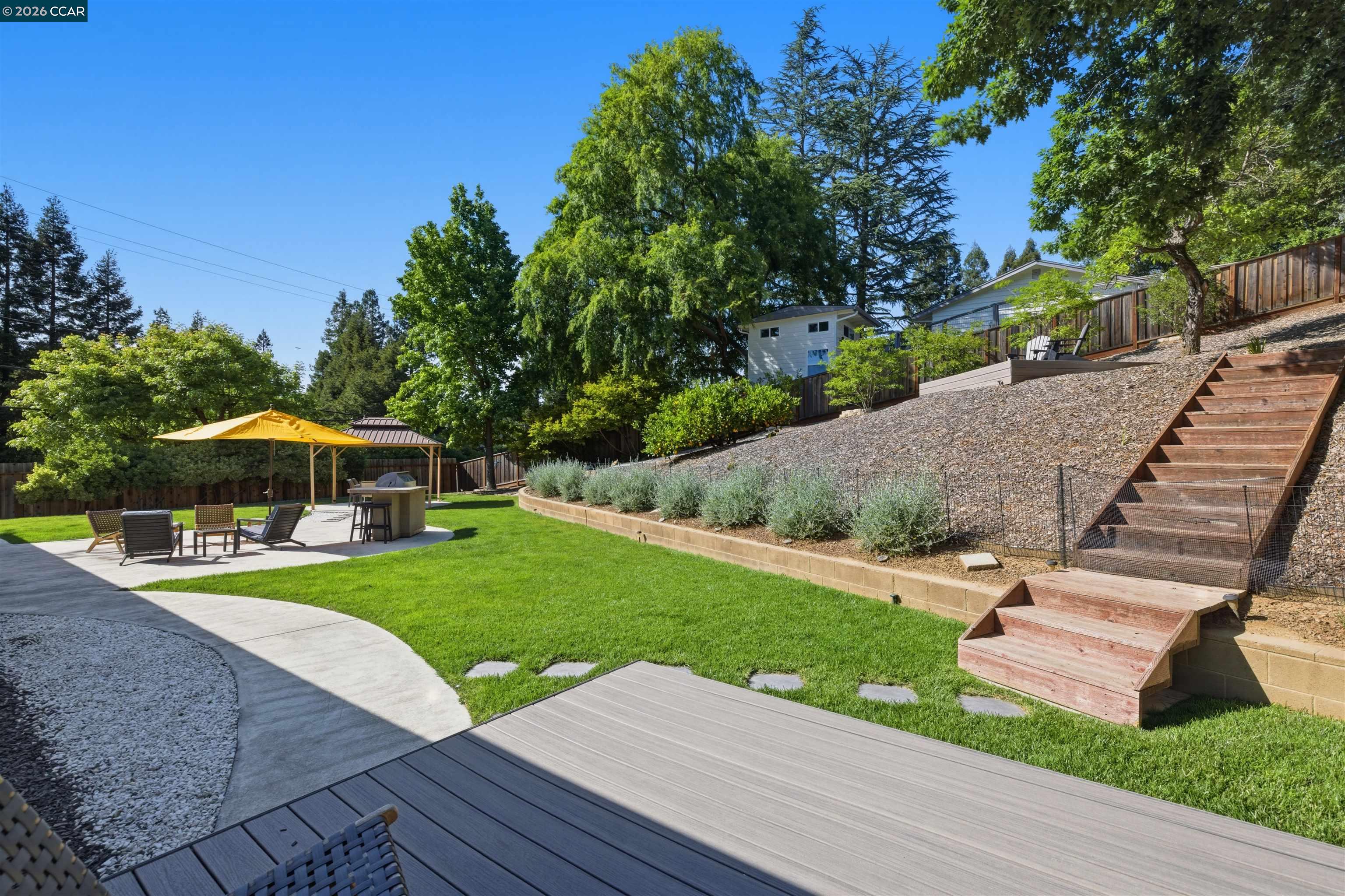 3298 Gloria Terrace Lafayette, CA 94549 - Photo 13 of 40 a view of a patio with a table and chairs under an umbrella