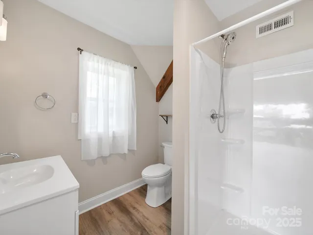 a view of a livingroom with wooden floor and stairs