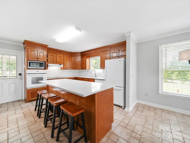 a open kitchen with a table chairs and a refrigerator