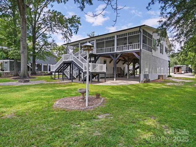 a front view of a house with garden and trees