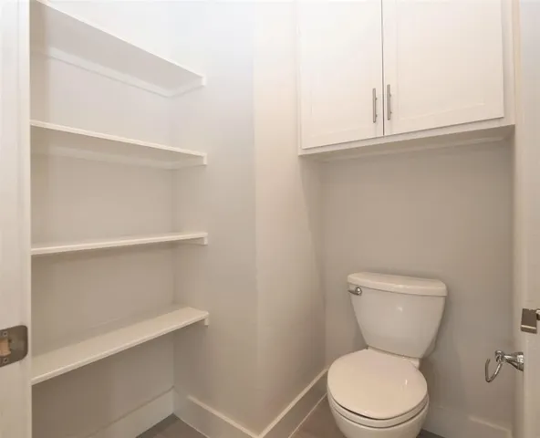 a white toilet sitting next to a window