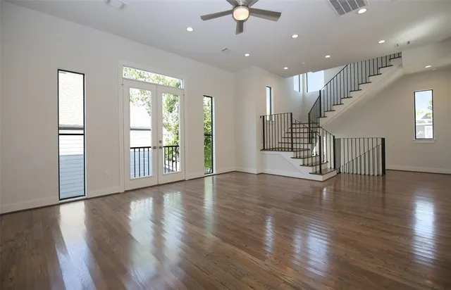 an empty room with wooden floor and windows