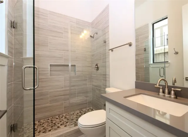 a bathroom with a sink a toilet and shower