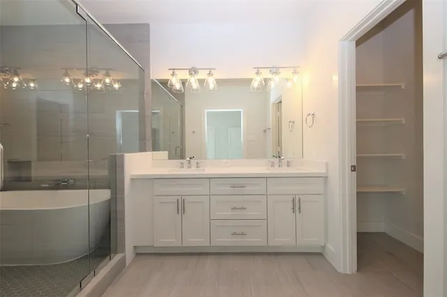 a bathroom with a double vanity sink mirror and a bathtub