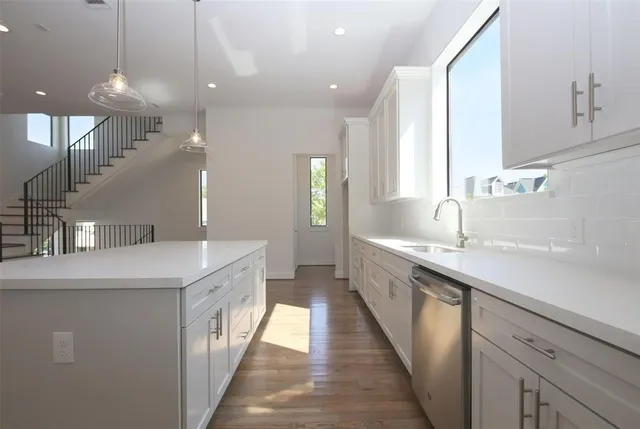 a large kitchen with a sink and cabinets