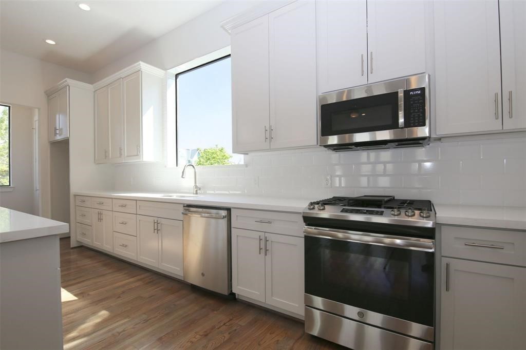 820 West 22nd Street Houston, TX 77008 - Photo 6 of 28 a kitchen with stainless steel appliances granite countertop a stove a microwave and white cabinets