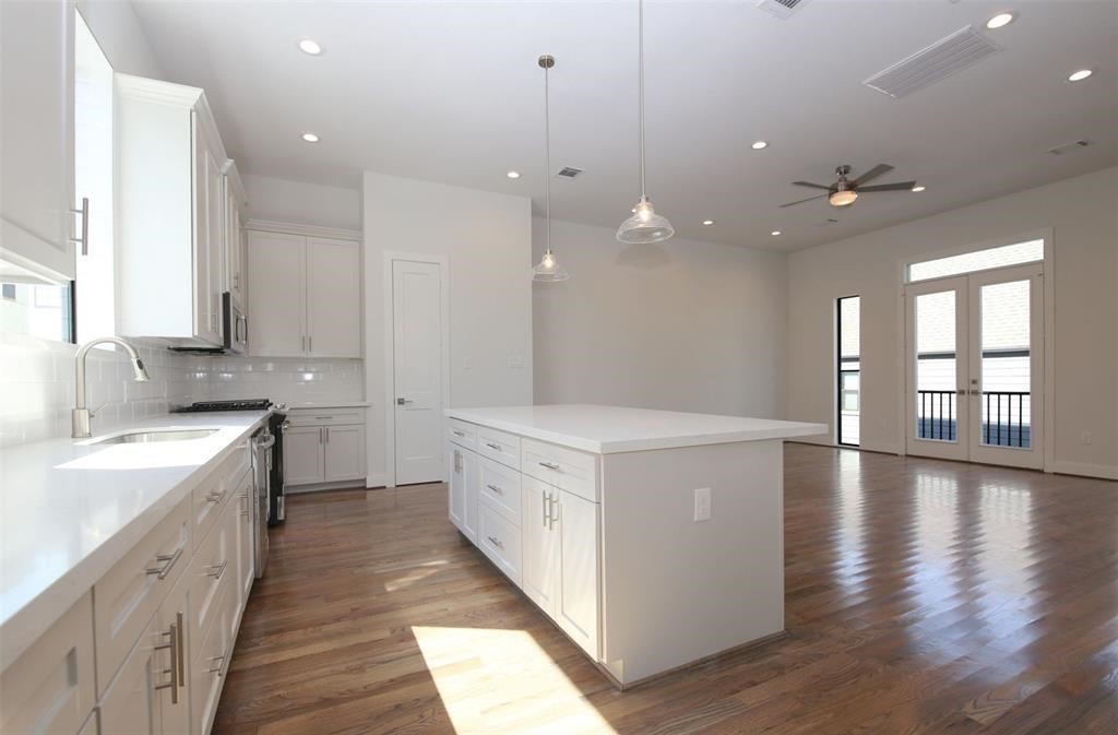 820 West 22nd Street Houston, TX 77008 - Photo 7 of 28 a large kitchen with stainless steel appliances a large counter top a sink a window and a refrigerator