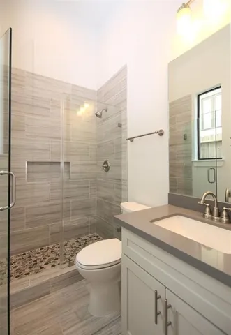 a bathroom with a sink a toilet and shower