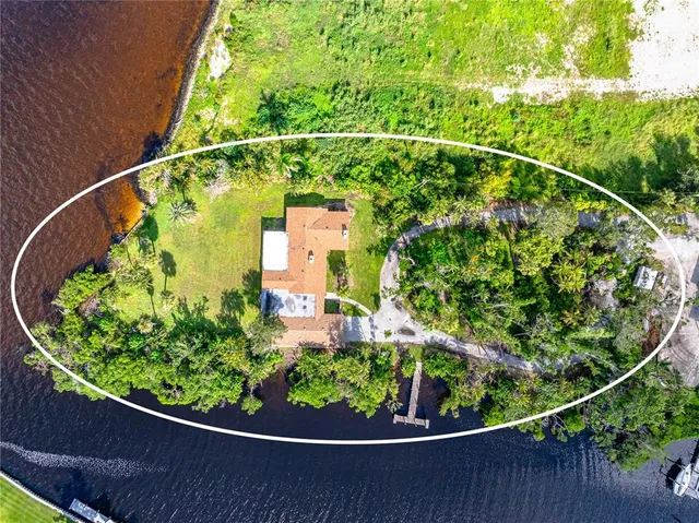 a view of a swimming pool with lawn chairs and plants