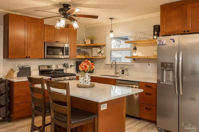 a kitchen with stainless steel appliances granite countertop a sink a stove and a refrigerator