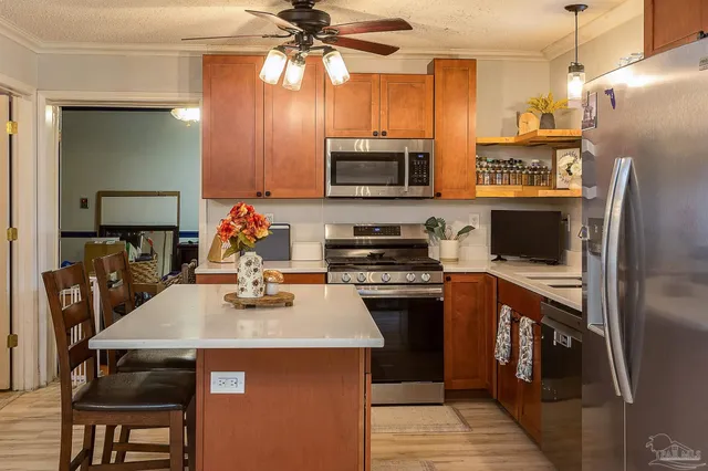 a kitchen with stainless steel appliances a stove refrigerator and microwave