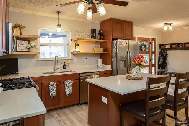 a kitchen with stainless steel appliances a sink a stove a refrigerator and cabinets