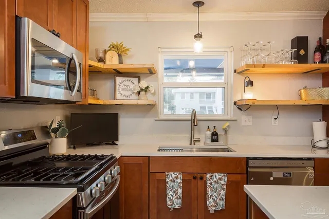 a kitchen with stainless steel appliances granite countertop a stove and a microwave