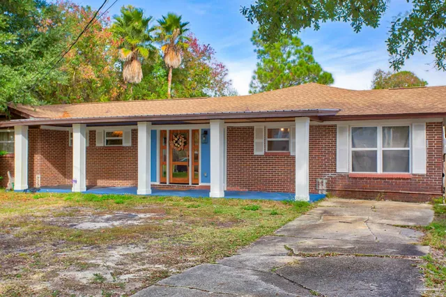 a front view of a house with a garden and yard