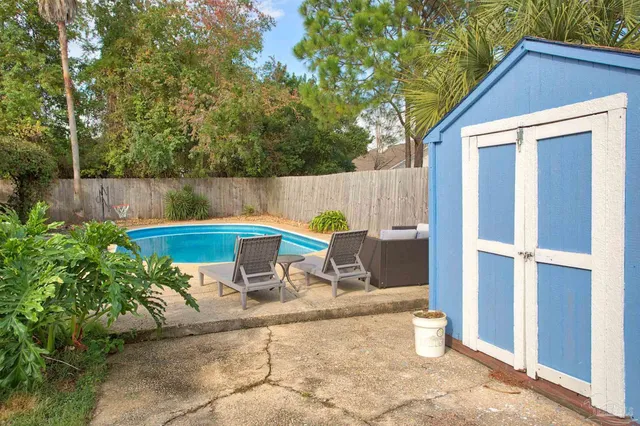 a view of backyard with a table and chairs in patio