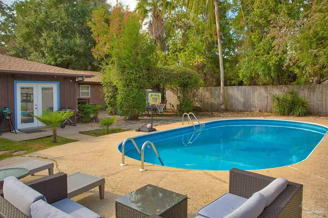 a view of swimming pool with outdoor seating and plants