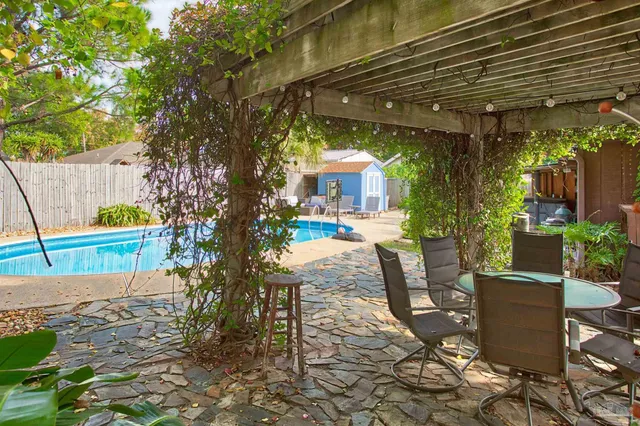 a view of a patio with table and chairs potted plants and large tree