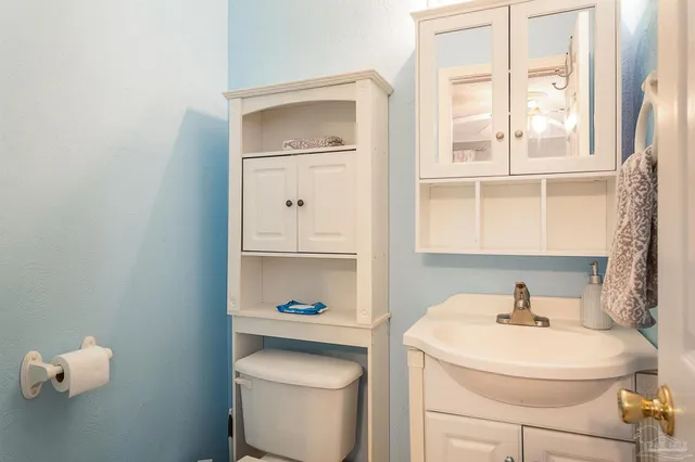 a bathroom with a sink toilet and a mirror