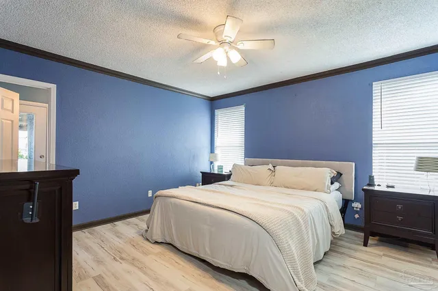 a bedroom with a bed and a ceiling fan