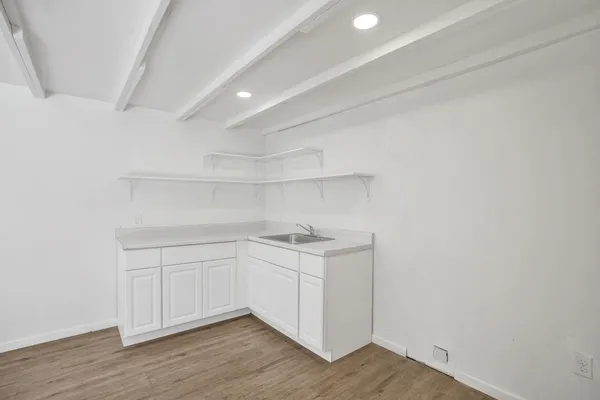 a kitchen with a sink cabinets and wooden floor