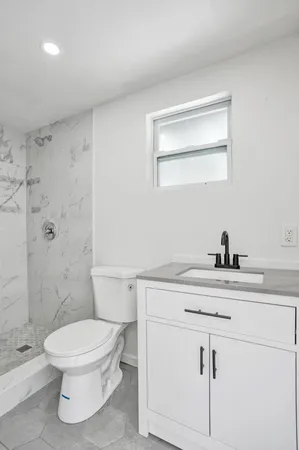 a bathroom with a sink a toilet and shower