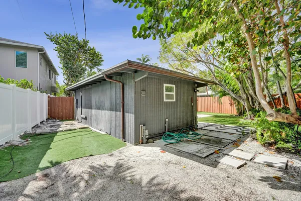 a view of a house with a yard and potted plants