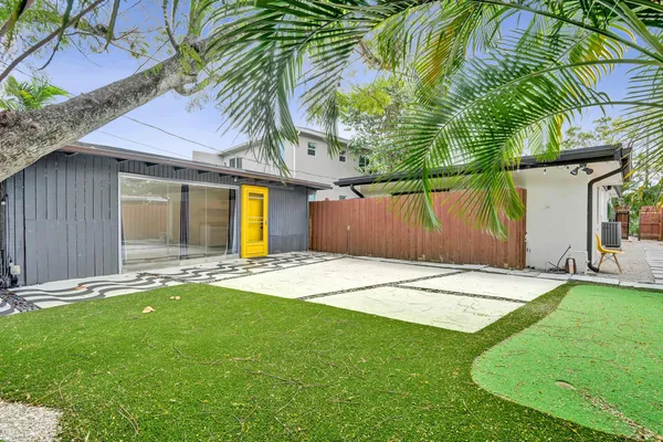 a backyard of a house with table and chairs