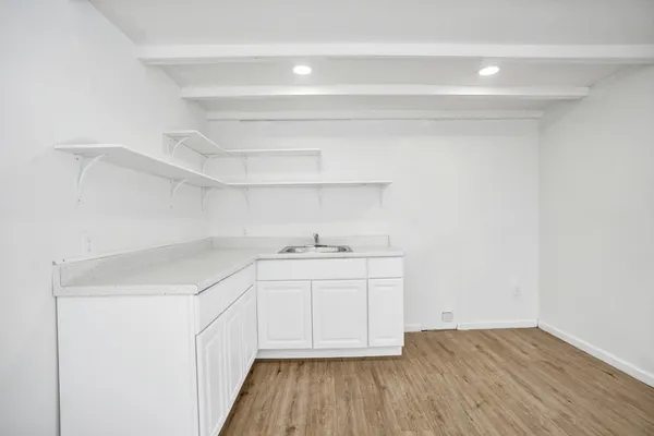 a kitchen with a sink cabinets and wooden floor