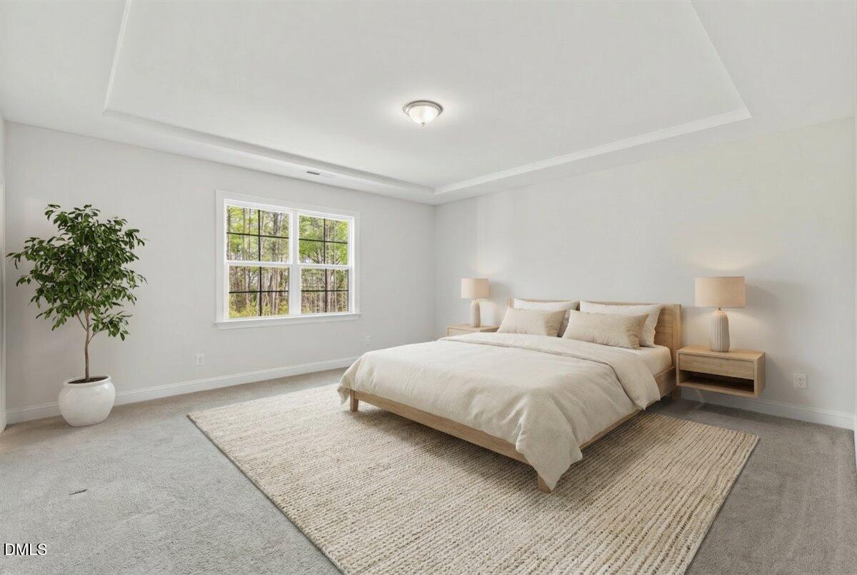 4937 Abundance Avenue Raleigh, NC 27616 - Photo 17 of 36 a bedroom with a large bed and a potted plant