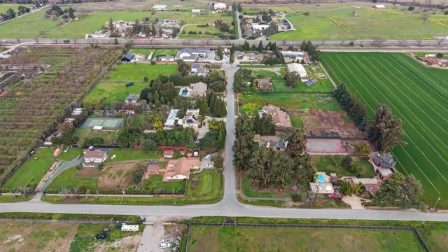 an aerial view of a residential houses with outdoor space and street view