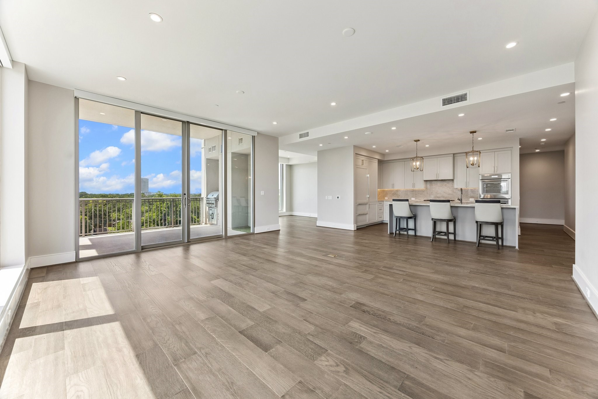 5656 San Felipe Street, Unit 701 Houston, TX 77056 - Photo 7 of 44 Actual unit photo showcasing the seamless Living /Kitchen flow with double sliding glass doors leading to a large private terrace.