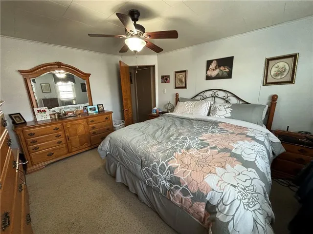 a bed sitting in a bedroom and a flat tv screen on dresser