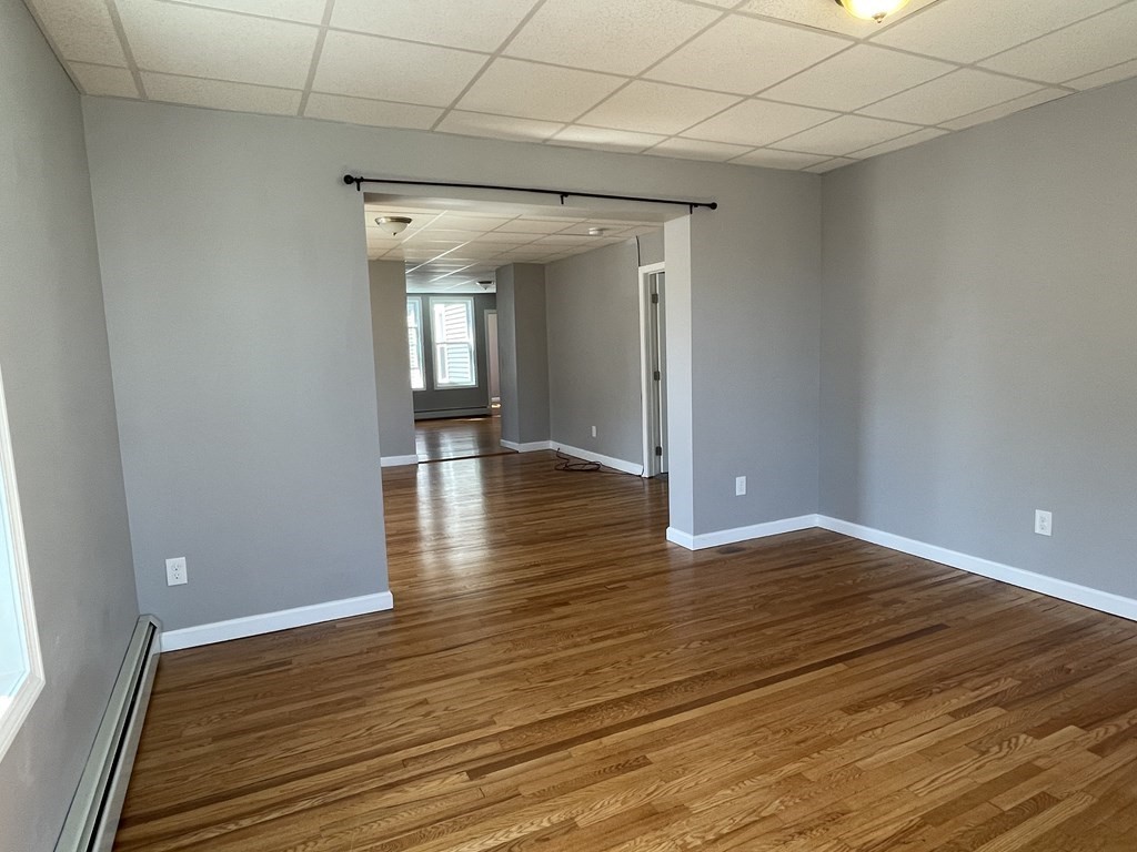 857 2nd Street Fall River, MA 02721 - Photo 3 of 38 a view of an empty room with wooden floor and a window