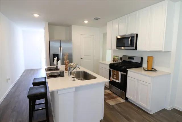 a kitchen with a sink a stove and a microwave