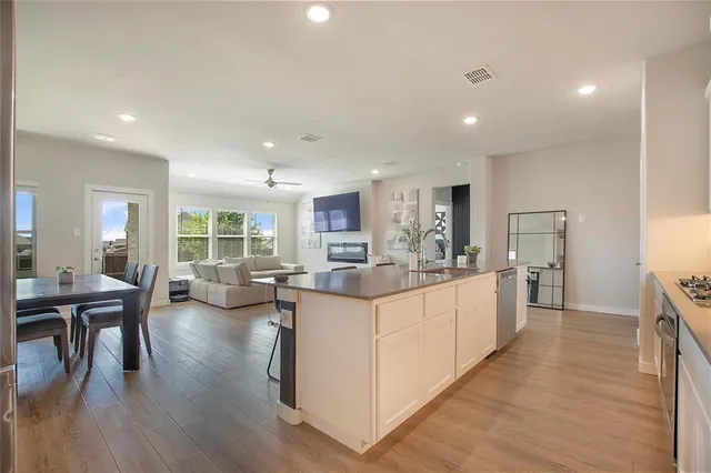 a large white kitchen with lots of counter top space and stainless steel appliances