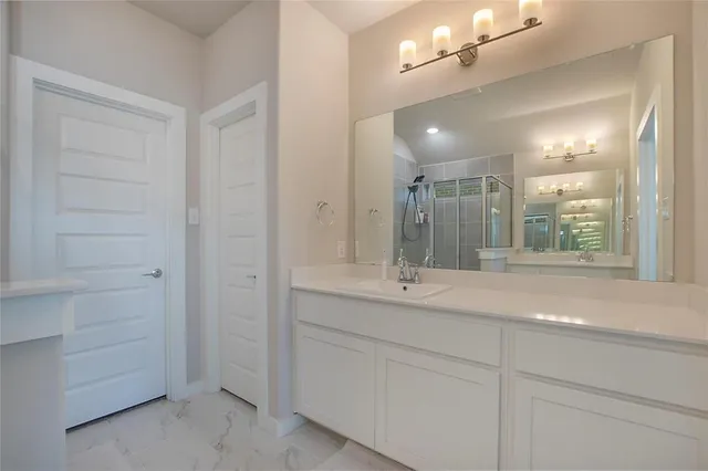 a bathroom with a shower sink and mirror