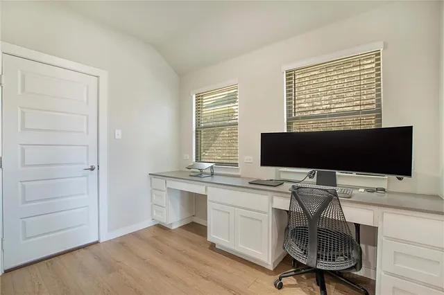 a view of a workspace with furniture and a window