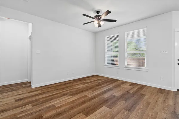 a view of a room with wooden floor and chandelier fan