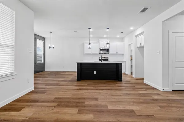 an empty room with a ceiling fan and wooden floor