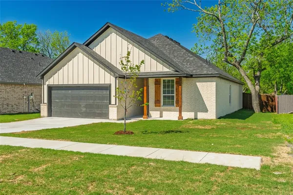 a front view of a house with a yard and garage