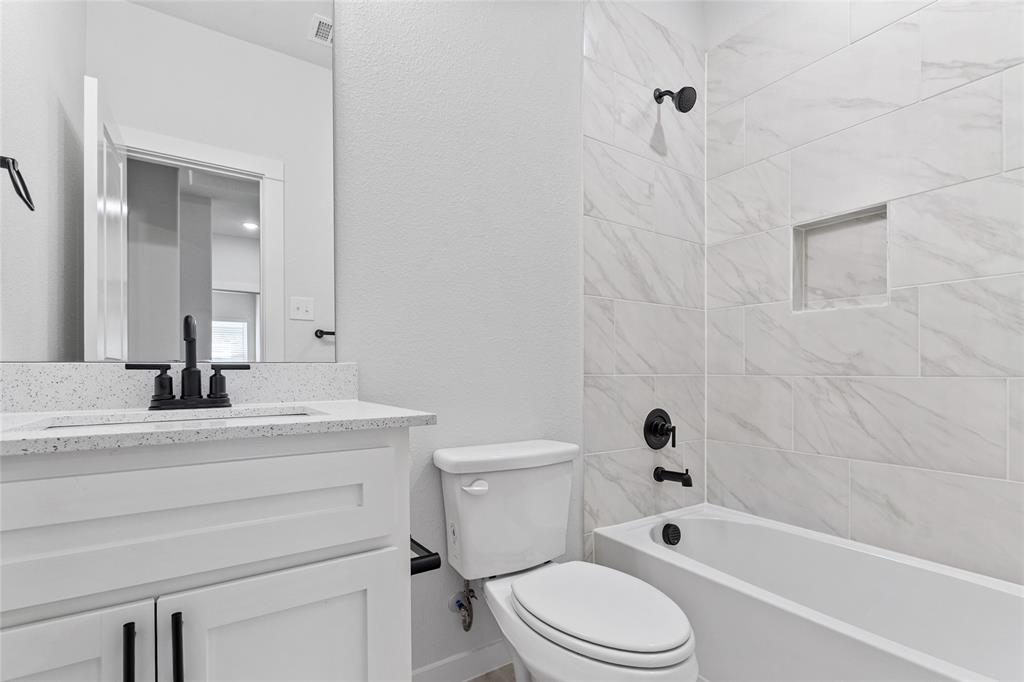 113 3rd Street Celeste, TX 75423 - Photo 33 of 39 a bathroom with a granite countertop toilet a sink and a bathtub