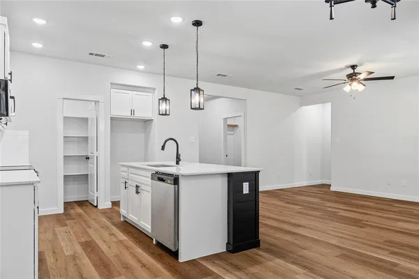a kitchen with white cabinets stainless steel appliances and sink