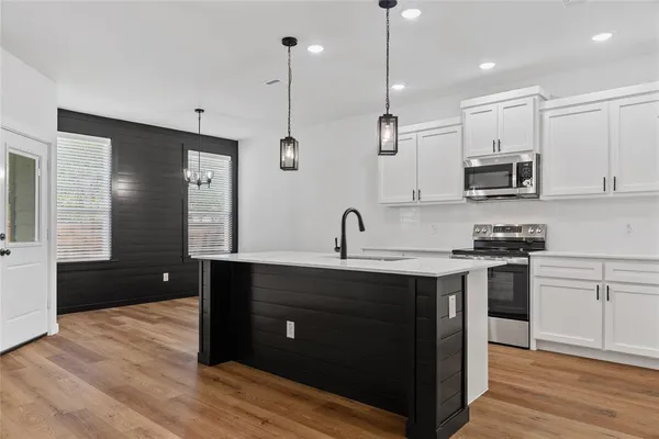 a kitchen with a sink and a stove top oven