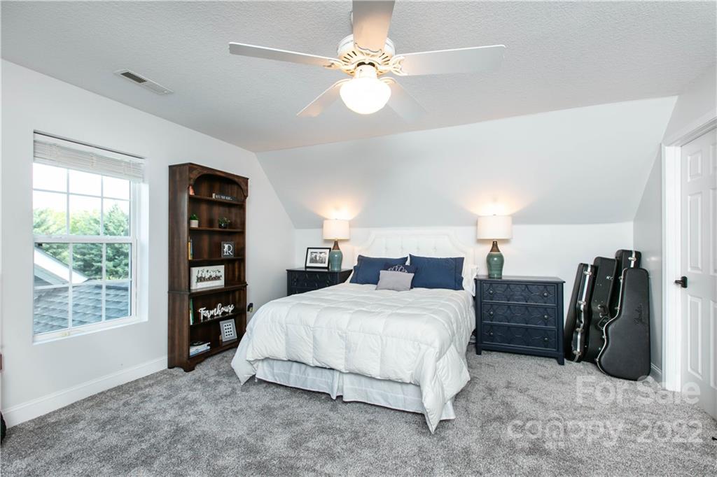 991 Golf Course Road Tryon, NC 28782 - Photo 16 of 43 a bedroom with a bed and a chandelier