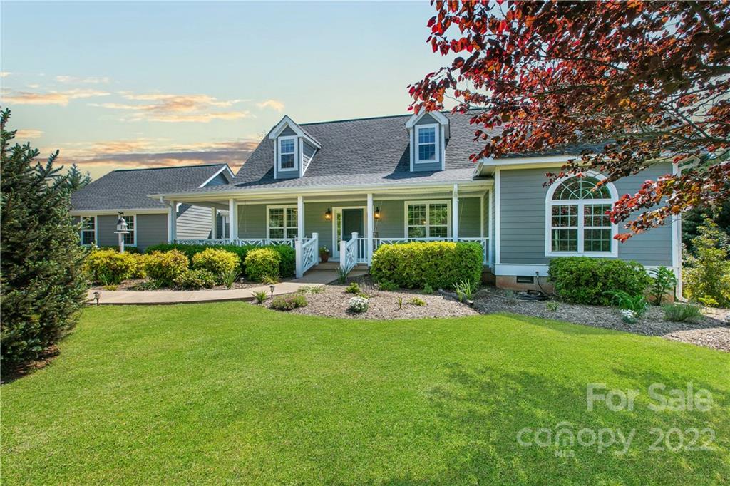 991 Golf Course Road Tryon, NC 28782 - Photo 20 of 43 a front view of a house with a yard and potted plants