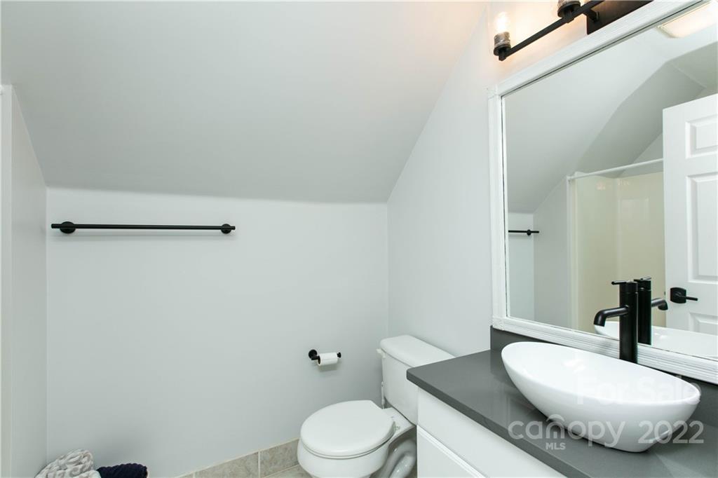 991 Golf Course Road Tryon, NC 28782 - Photo 28 of 43 a bathroom with a granite countertop sink mirror vanity and toilet